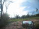 1995 Ford C-350 (Centurion Conversions) - Rural landscape with trees and a dirt road, viewed from inside a vehicle.