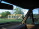 1995 Ford C-350 (Centurion Conversions) - View from inside a vehicle shows a construction site with a roof structure being built, built with concrete pillars and wooden beams.