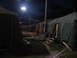 1995 Ford C-350 (Centurion Conversions) - A temporary tent city is lit up at night, with multiple tents lined up and a single floodlight illuminating the scene.