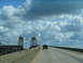 1995 Ford C-350 (Centurion Conversions) - Driving on a highway overpass with distinctive bridge towers and a single vehicle ahead.
