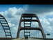 1995 Ford C-350 (Centurion Conversions) - A truck travels across a large bridge with distinctive arch structures.