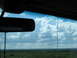 1995 Ford C-350 (Centurion Conversions) - View from inside a vehicle, showing a cloudy sky above a dense green forest.
