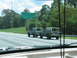 1995 Ford C-350 (Centurion Conversions) - Two olive drab SUVs are seen driving on a highway, passing a green sign for Montgomery Youth Soccer Fields.