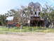 1995 Ford C-350 (Centurion Conversions) - Building severely damaged, showing exposed metal structure and debris after an event.
