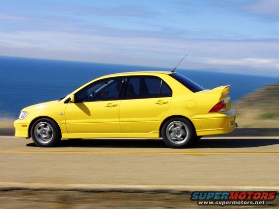 Yellow sedan driving on a coastal road
