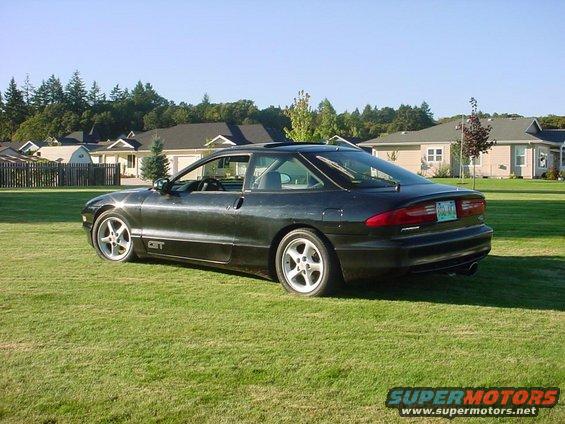 Dark 1994 Ford Probe GT parked on a grassy lawn with houses in the background