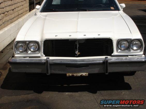 White Ford Ranchero front view, missing grille, chrome bumper, dual headlights