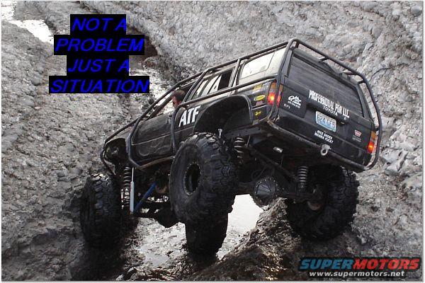 Black Toyota 4Runner with large tires and roll cage climbing over rocks