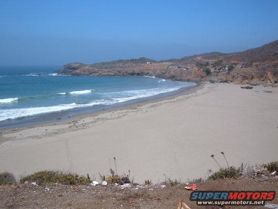 Beach scene with ocean waves and distant buildings