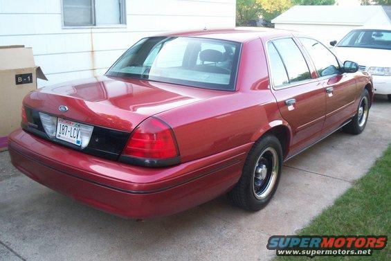 Red 2001 Ford Crown Victoria parked on driveway, another white car visible behind it