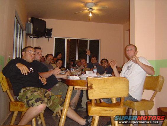 Group of people gathered around a wooden table indoors