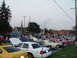 2003 Ford Crown Victoria - A gathering of vehicles at an outdoor event, with several cars on display and people milling around.