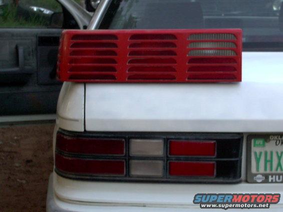 red car taillight assembly on top of white car trunk