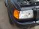 2003 Ford Ranger - Front view of a black 2003 Ford Ranger with the hood open, showing the headlight and grille.