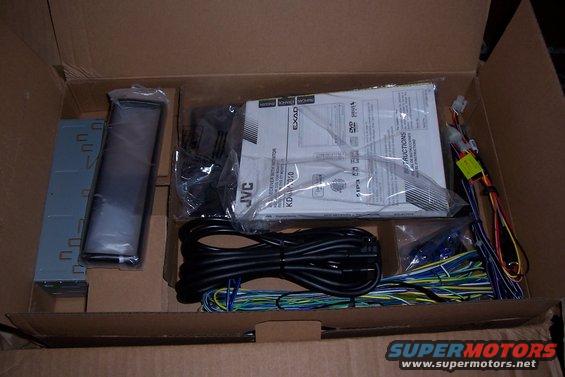 Car stereo components including JVC KD-AV7010 receiver, wiring, and manual in a cardboard box