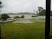 1978 Ford F-250 - A boat is visible in the distance on choppy water during a storm, with flooded land in the foreground.