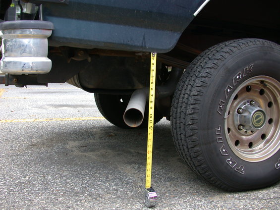 Exhaust pipe measured with tape measure next to rear tire