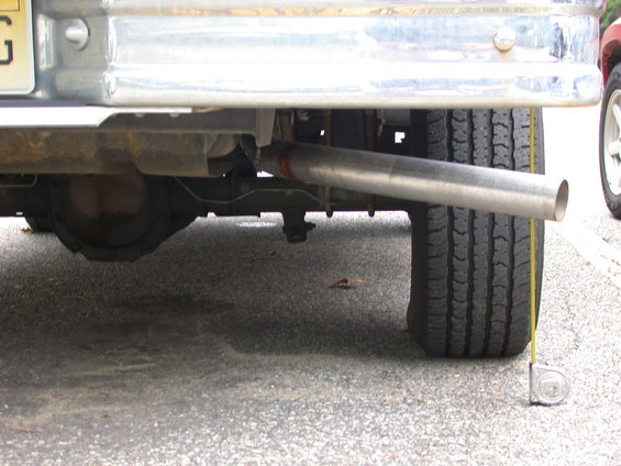 Rear axle and exhaust pipe of a vehicle, with a tape measure on the ground