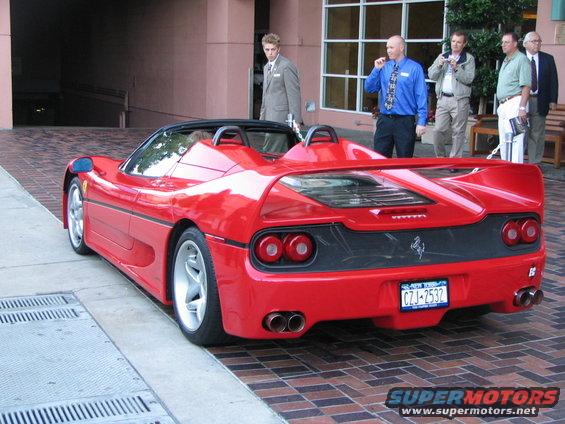 Red Ferrari F50 convertible parked on brick and concrete, rear view. License plate CZJ-2532