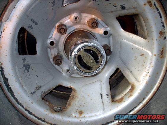 Close-up of a Warn locking hub on a silver wheel with rust spots
