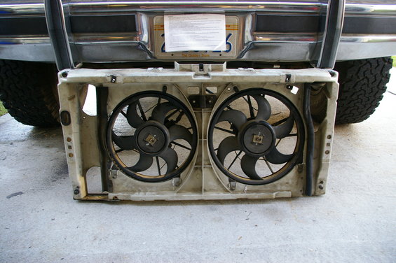 Dual electric fans removed from vehicle rear. License plate visible