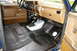 1986 Ford Bronco - The interior of a truck shows a black spray-on bedliner applied to the floor and lower door panels.