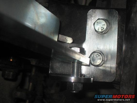 Metal bracket bolted to frame with visible Supermotors.net watermark