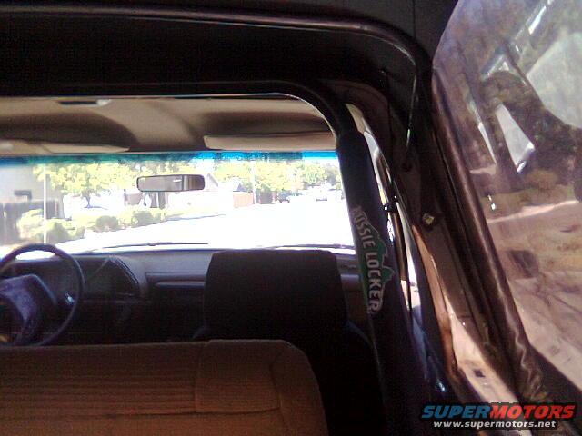 Interior view of a vehicle with a roll bar and "AUSSIE LOCKER" text, showing dashboard and steering wheel