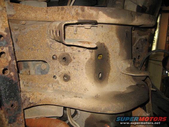 rusted frame section with bolts and some fluid stains