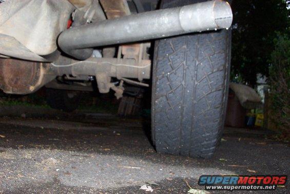 Close-up of a vehicle's exhaust pipe and tire