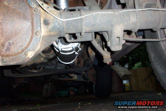 Underside view of a vehicle's rear axle, suspension, and part of the exhaust system