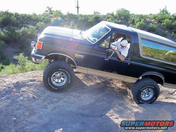 Dark blue 1991 Ford Bronco climbing rocky terrain