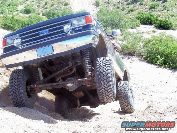 1991 Ford Bronco off-roading, front 3/4 view, dark blue
