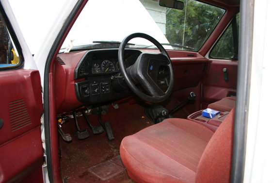 1987 Ford Bronco interior, red seats and dashboard, viewed from passenger side