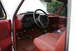 1987 Ford Bronco - The interior of a 1987 Ford Bronco shows red seats and dashboard with a black steering wheel.