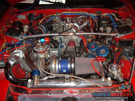 Engine bay with turbocharger, intercooler, and custom piping. Text reads 'SUPER MOTORS'