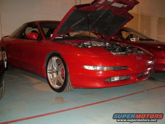 1991 Ford Probe with hood open, showing engine bay. Another red car is parked behind it