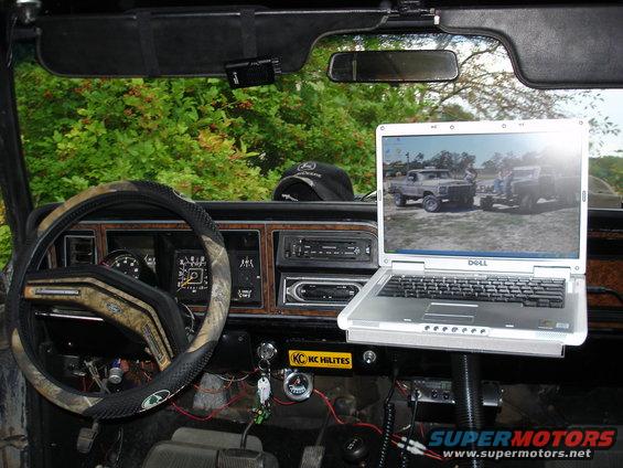 1979 Ford Bronco interior with a laptop on a mount, camouflage steering wheel cover, and aftermarket gauges
