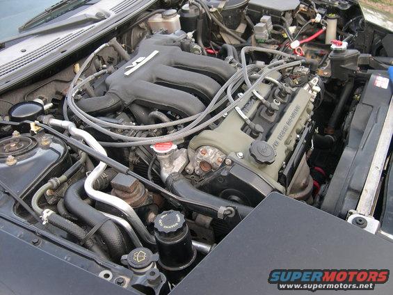 Engine bay of a 1997 Ford Probe, showing the V6 engine with black intake manifold and green valve covers
