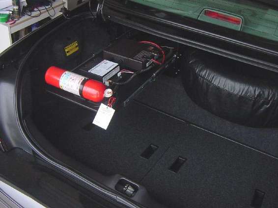 Trunk interior with fire extinguisher, electronic equipment, and spare tire cover