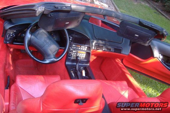 Red leather interior of a 1994 Chevrolet Corvette convertible, showing the dashboard, steering wheel, and seats