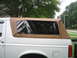 1996 Ford Bronco - This 1996 Ford Bronco features a tan soft top with clear plastic windows, seen from the side.