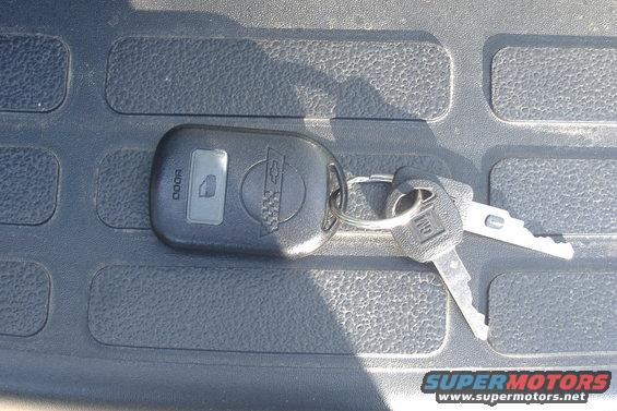 Car keys with Chevrolet and GM logos on textured surface