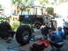1994 Jeep YJ - Three men work on a lifted 1994 Jeep YJ, which is supported by jack stands and has its rear axle removed.