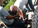 1994 Jeep YJ - A close-up view of mechanics working on a vehicle's differential and axle components.
