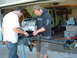 1994 Jeep YJ - Two men are working on the front axle of a classic Ford Bronco in a garage setting.