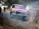 1979 Ford Bronco - A red 1979 Ford Bronco navigates a dusty off-road path, with another vehicle ahead.