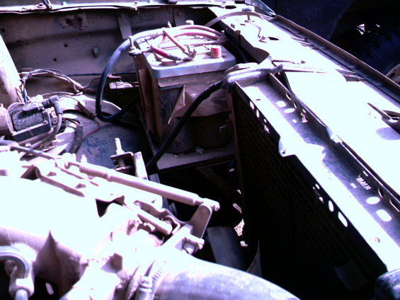Engine bay showing two batteries, radiator, and engine components