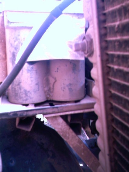 dual batteries mounted on a bracket, next to a radiator