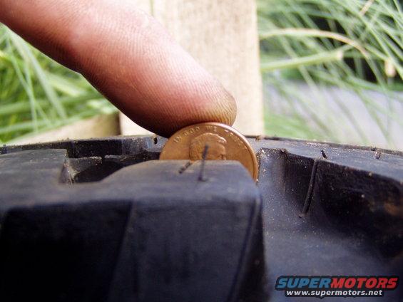 Tire tread depth measured with a penny, showing Lincoln's head